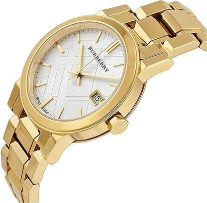 Burberry The City watch at angle showing white dial, date window, and gold bracelet