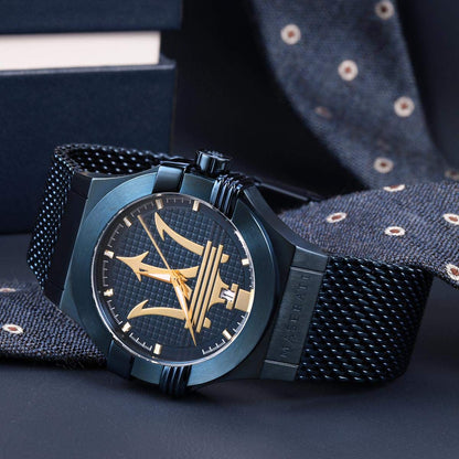 Close-up of blue dial with gold trident logo, hour markers, and gold hands